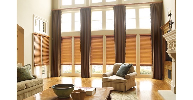 Southern California great room with wooden blinds and floor to ceiling drapes.